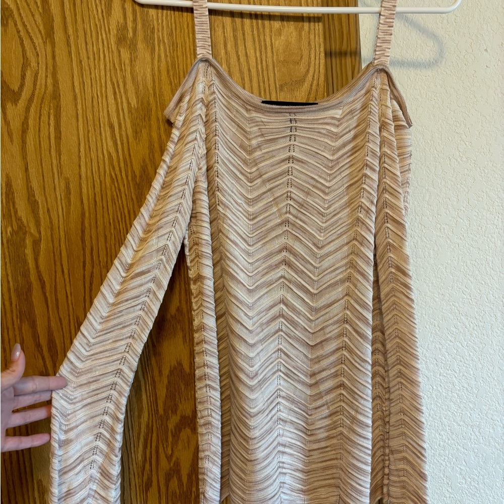 Light sweater with exposed shoulder and wide scalloped hemming.